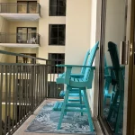 Balcony with two bright blue wooden chairs