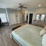 Main bedroom with bed, dresser, closet, and tv