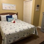 Yellow bedroom with closet and dresser decorated in a beachy theme