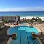 Beach front hotel pool with lounge chairs around it