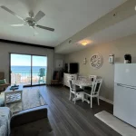 View of a living space in a hotel room with a dinning area, balcony, and fridge