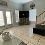 Living room with a tv, stairway, and french doors