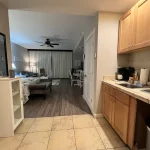 View of a hotel kitchen and studio living space, including a bed, living area, and dining area