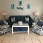 Couch, two chairs, and a coffee table with nautical decorations