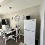 View of a living space in a hotel room with a dinning area, tv, and fridge