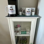 A small coffee station with a Keurig, mugs, and k-cups