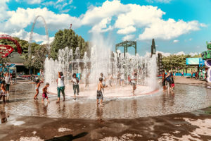 Splash pad with kids playing in it at an amusement park