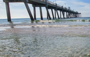 crashing waves on the shoreline of Fort Walton Beach with pier in the background
