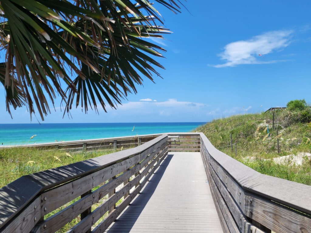 wooden bridge leading to the ocean on a clear day