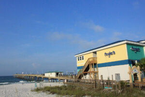 Angler's colorful building with pier on beach